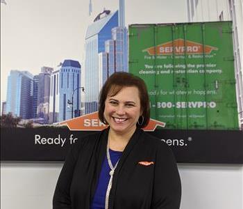 SERVPRO of Freehold shares picture of one of their females project managers smiling and standing in front of a SERVPRO Ad.